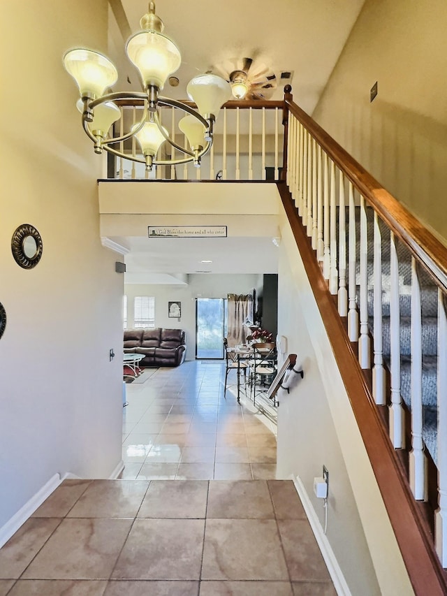 staircase with tile patterned flooring, a notable chandelier, and baseboards