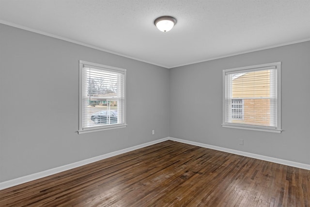 empty room with baseboards, ornamental molding, and dark wood-style flooring