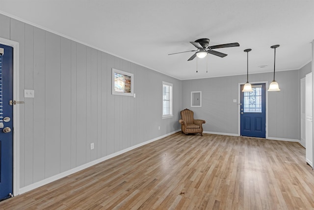 foyer entrance with baseboards, ornamental molding, a ceiling fan, and light wood finished floors