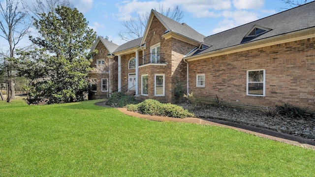 exterior space with brick siding and a front lawn