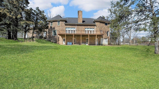 back of property with brick siding, a lawn, a chimney, and a deck