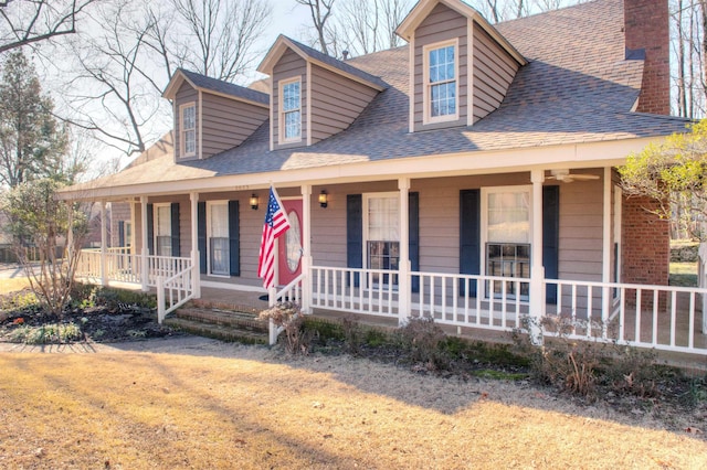 view of front of house featuring a porch, a front lawn, and a shingled roof