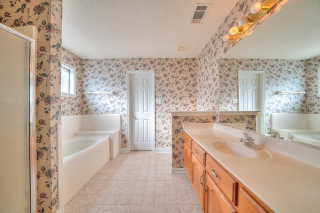 bathroom with visible vents, a textured ceiling, and wallpapered walls