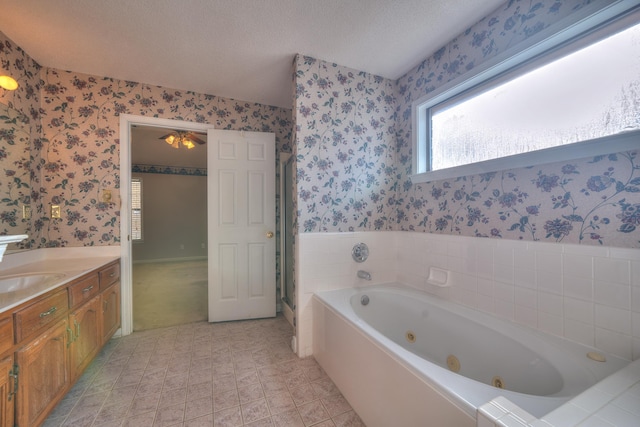 full bathroom with a shower stall, wallpapered walls, vanity, a tub with jets, and a textured ceiling