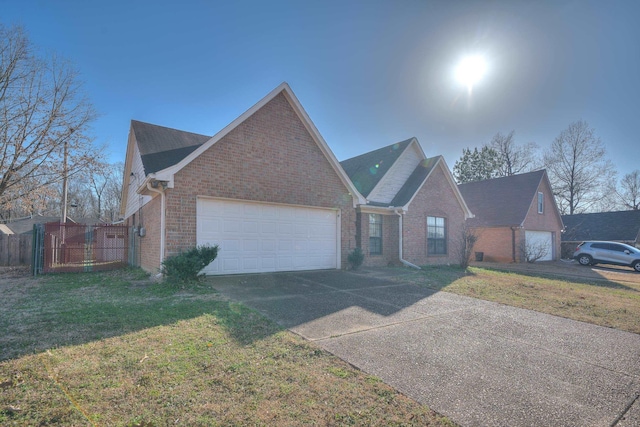 view of front facade featuring brick siding, fence, a front yard, driveway, and an attached garage