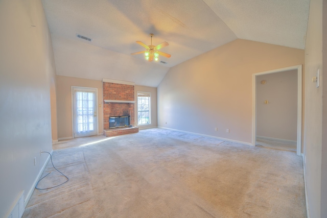 unfurnished living room featuring visible vents, light carpet, a fireplace, and a ceiling fan