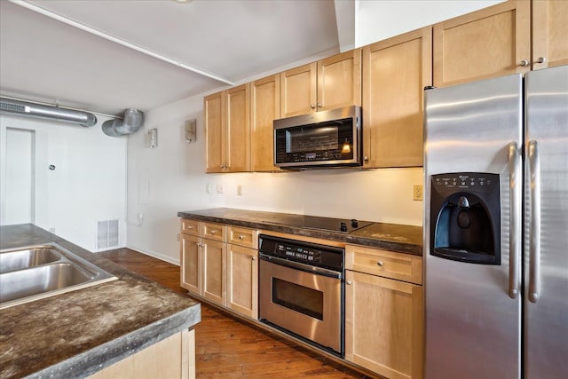 kitchen with visible vents, dark wood-type flooring, light brown cabinets, dark countertops, and appliances with stainless steel finishes