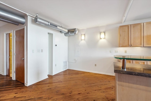 below grade area featuring visible vents, baseboards, and dark wood finished floors