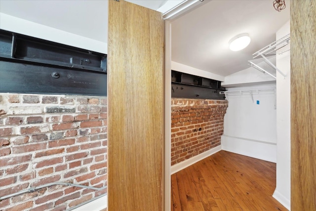 walk in closet featuring vaulted ceiling and wood finished floors