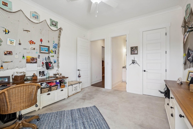 office featuring light colored carpet, baseboards, ceiling fan, and ornamental molding