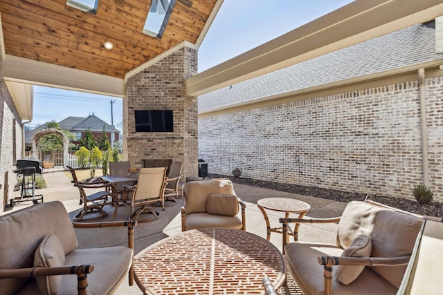 view of patio with outdoor dining area and an outdoor brick fireplace