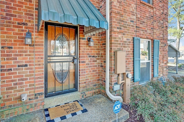 entrance to property featuring brick siding