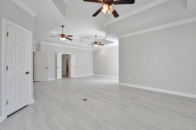 empty room with baseboards, crown molding, and a tray ceiling