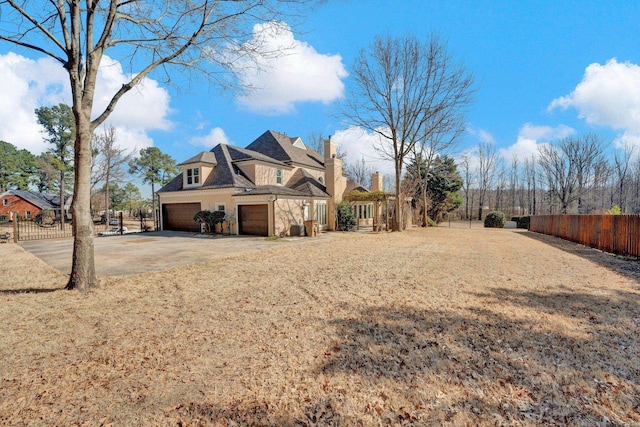 exterior space with driveway, an attached garage, and fence