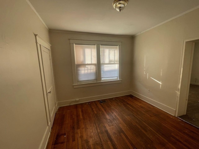 spare room with visible vents, baseboards, ornamental molding, and hardwood / wood-style flooring