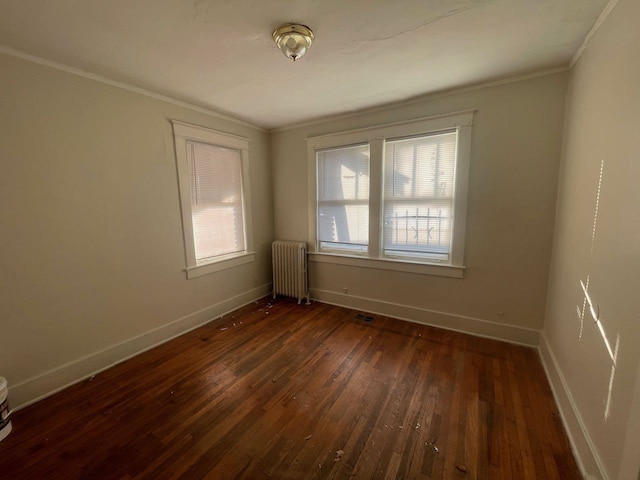 spare room featuring plenty of natural light, radiator, baseboards, and dark wood-style flooring