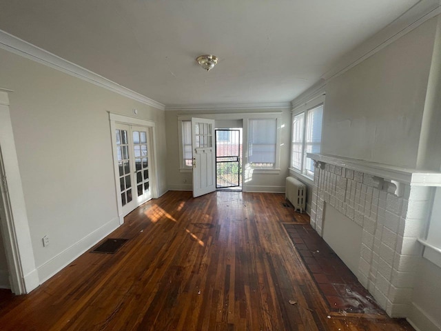 unfurnished living room featuring visible vents, ornamental molding, dark wood-style floors, radiator, and baseboards