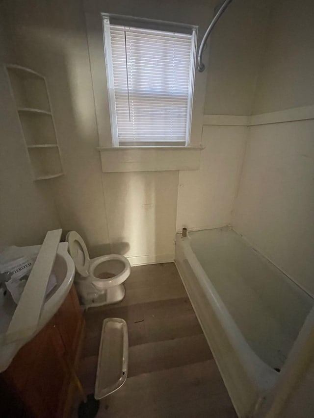 bathroom with toilet, wood finished floors, a bathing tub, and a shower