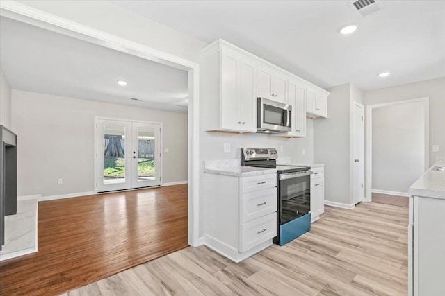 kitchen with visible vents, light wood finished floors, french doors, appliances with stainless steel finishes, and white cabinetry