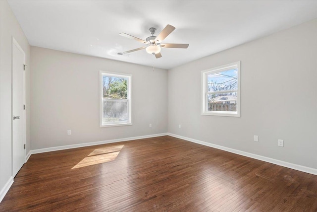 spare room with hardwood / wood-style floors, baseboards, visible vents, and a ceiling fan