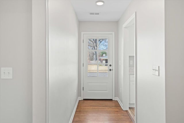 entryway featuring visible vents, baseboards, and wood finished floors