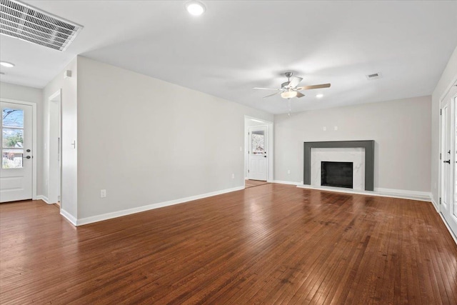 unfurnished living room featuring visible vents, a fireplace, baseboards, and wood-type flooring