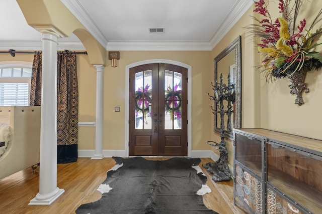 foyer entrance featuring visible vents, crown molding, decorative columns, french doors, and arched walkways