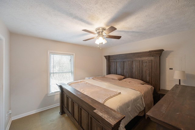 bedroom featuring a ceiling fan, light colored carpet, baseboards, and a textured ceiling