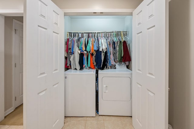 laundry room featuring washer and dryer, light tile patterned flooring, and laundry area