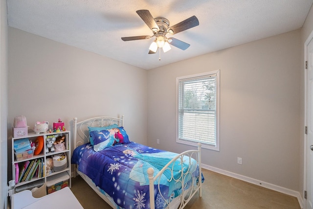 carpeted bedroom with ceiling fan, a textured ceiling, and baseboards