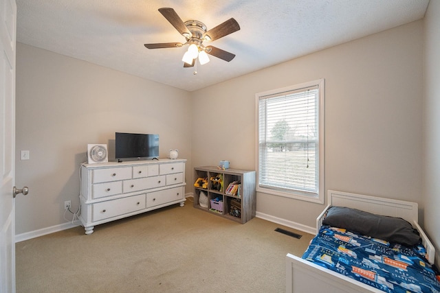 bedroom with visible vents, baseboards, light colored carpet, and a ceiling fan