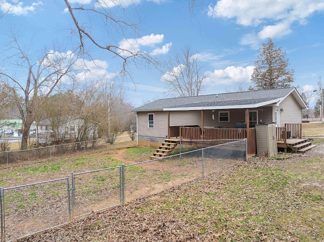 back of house with a deck, a gate, fence private yard, and roof with shingles