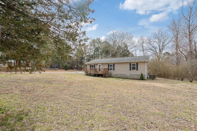 view of front of home with a wooden deck and a front lawn