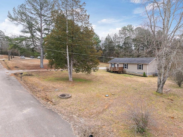 ranch-style home with a deck and a front lawn