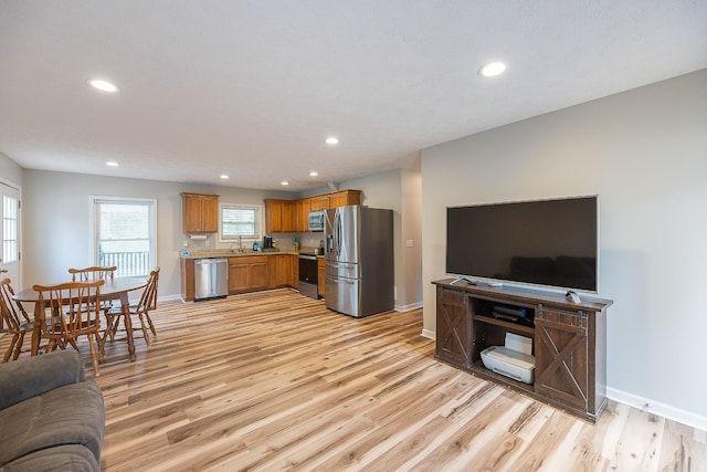 kitchen featuring light wood-type flooring, stainless steel appliances, and open floor plan