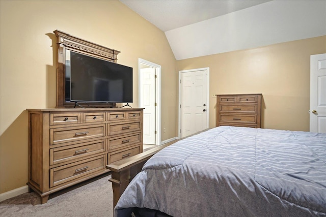 carpeted bedroom with baseboards and lofted ceiling