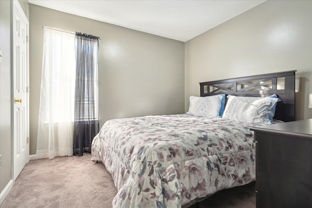 carpeted bedroom featuring a textured ceiling and baseboards