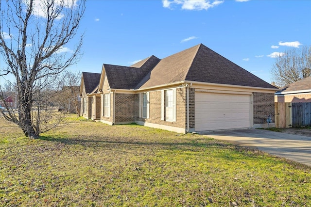 view of front of house with a front lawn, roof with shingles, concrete driveway, a garage, and brick siding