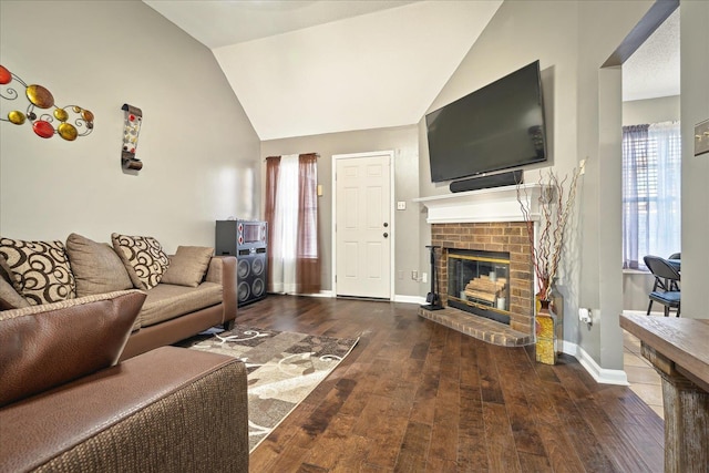 living area with baseboards, wood finished floors, a fireplace, and vaulted ceiling