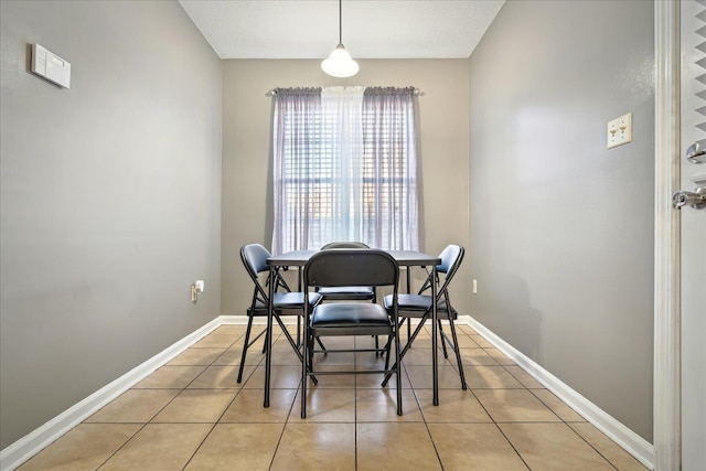 dining space featuring baseboards and light tile patterned flooring