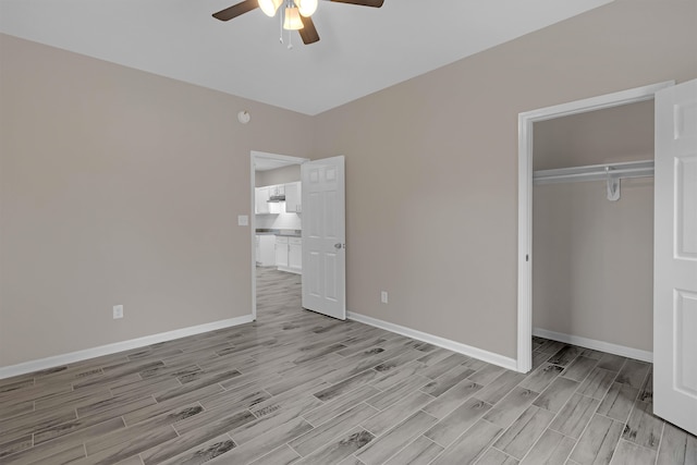 unfurnished bedroom with a closet, a ceiling fan, baseboards, and wood tiled floor