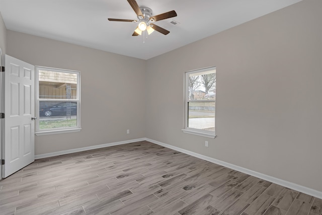 empty room featuring visible vents, light wood-style floors, baseboards, and ceiling fan