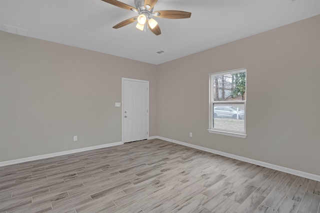 empty room featuring light wood-type flooring, baseboards, and a ceiling fan