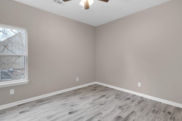 unfurnished room with wood finish floors, visible vents, baseboards, and ceiling fan