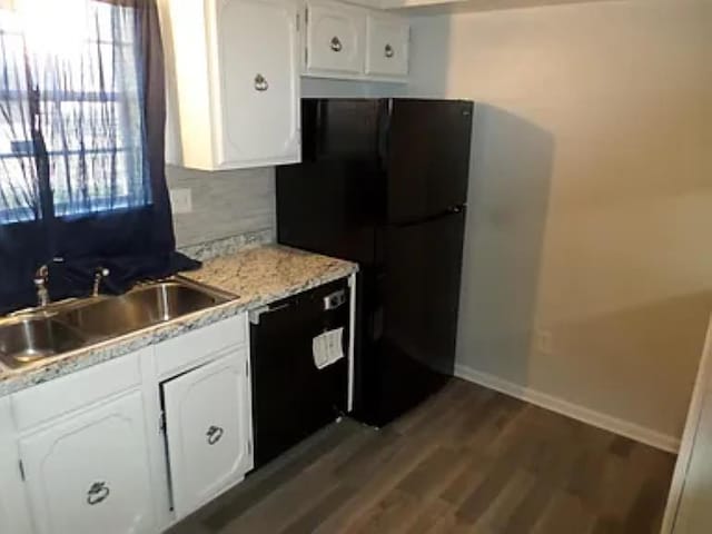 kitchen featuring wood finished floors, baseboards, a sink, black appliances, and white cabinetry