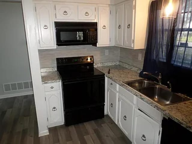 kitchen featuring black appliances, white cabinets, visible vents, and a sink