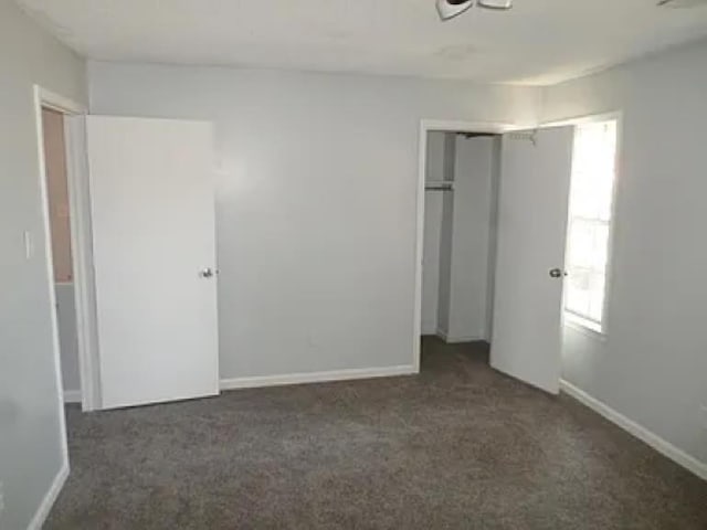 unfurnished bedroom with a closet, baseboards, and carpet