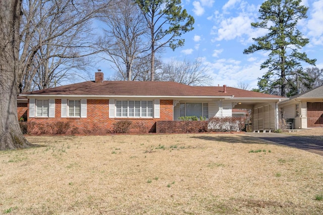 ranch-style home with brick siding, driveway, a chimney, and a front lawn