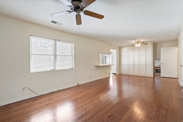 unfurnished living room with visible vents, ceiling fan, ornamental molding, hardwood / wood-style flooring, and a textured ceiling