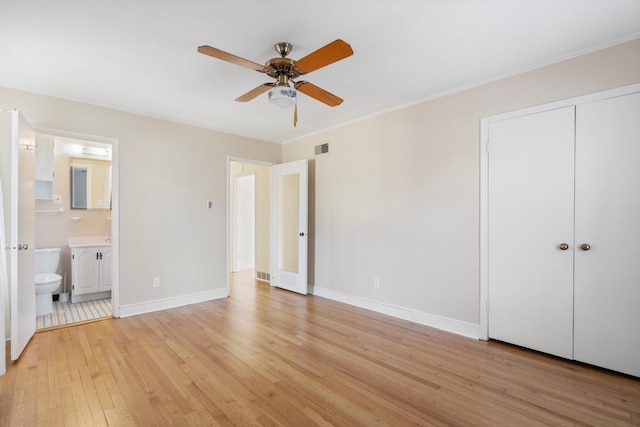 unfurnished bedroom with visible vents, baseboards, ensuite bath, light wood-style floors, and crown molding